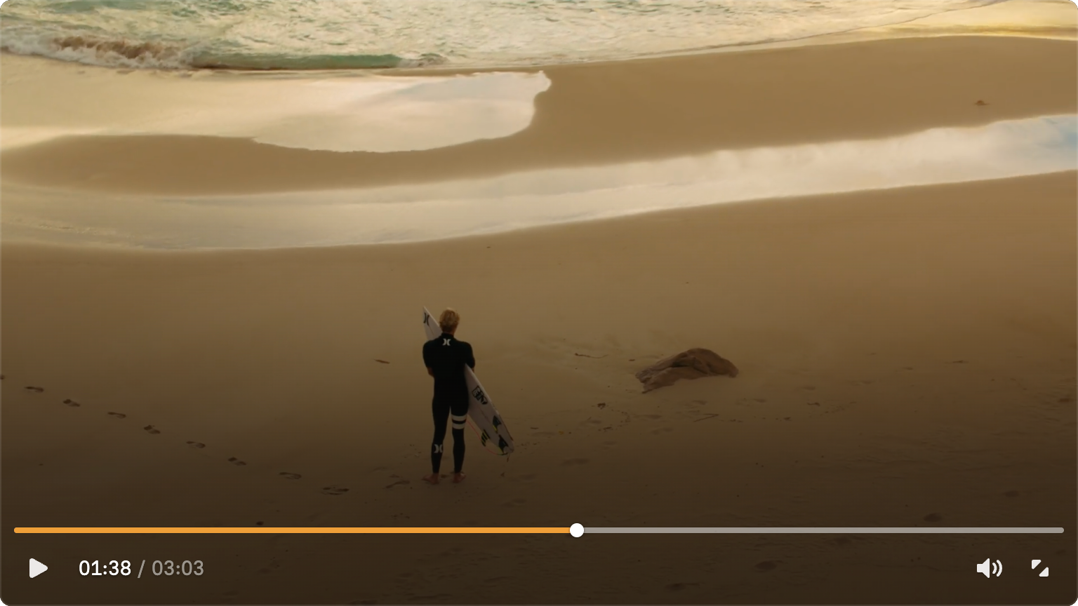 An early skin exploration over a beach video, with an amber timeline above a row of playback controls.